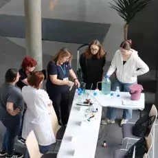 studenci przygotują się na stoisku na przybycie gości